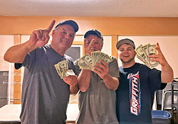 Three campers in the rec hall fanning out their winnings after a card game