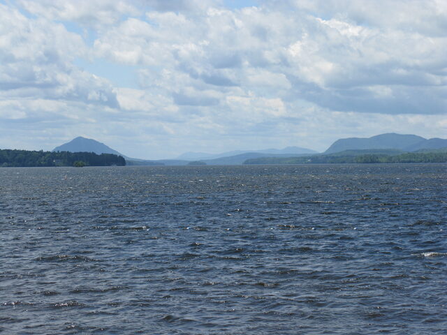 Lake Memphremagog under a broad sky, with the mountains of the Northeast Kingdom along the far shore