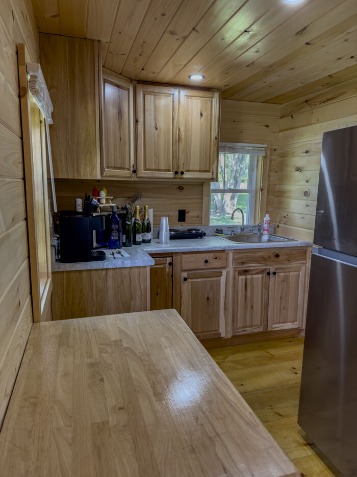 The kitchen seen from the doorway, with the table, the cabinets and the refrigerator