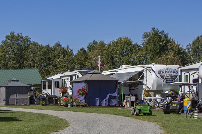 Campers lined along the gravel road with their awnings out