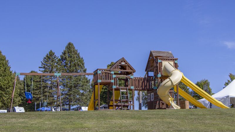 The wooden playground tower and slides on the open field
